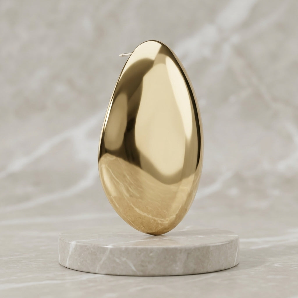Aurelia polished gold-tone teardrop earring on a round stone pedestal