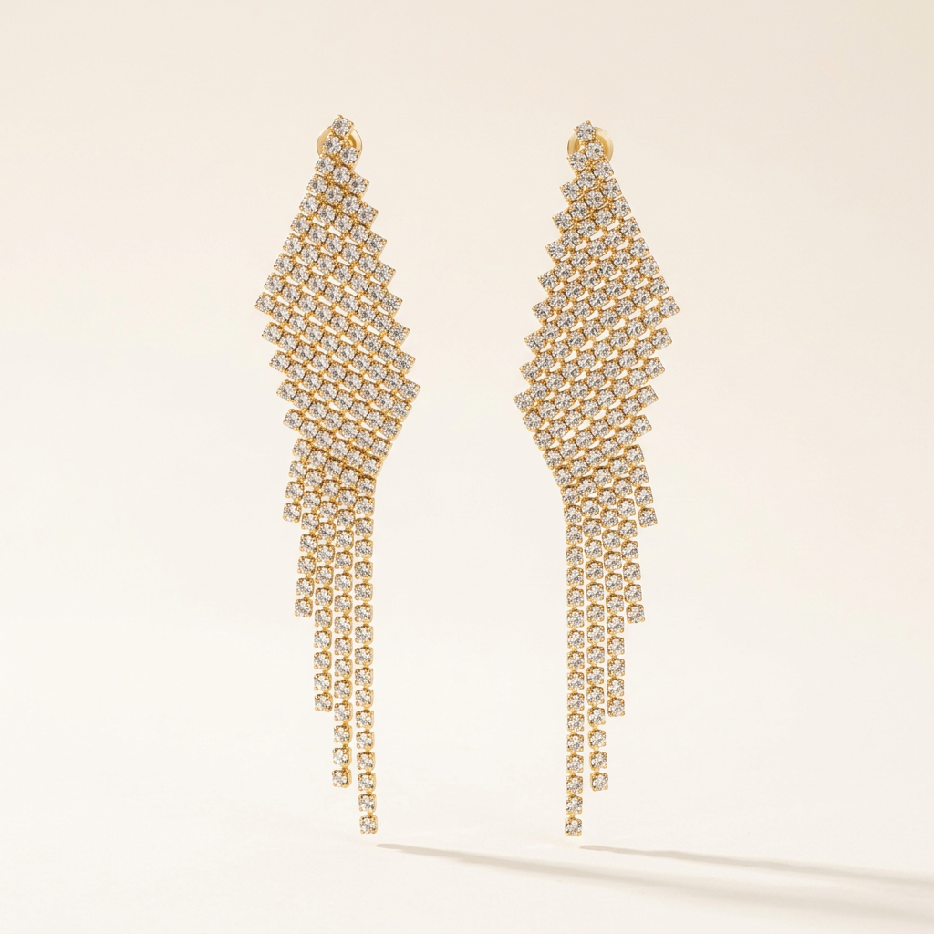 Gold-tone Celeste Cascade earrings with clear stones and cascading fringe on an ivory background