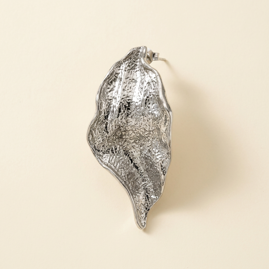Silver-tone textured sculptural petal earring on an ivory background